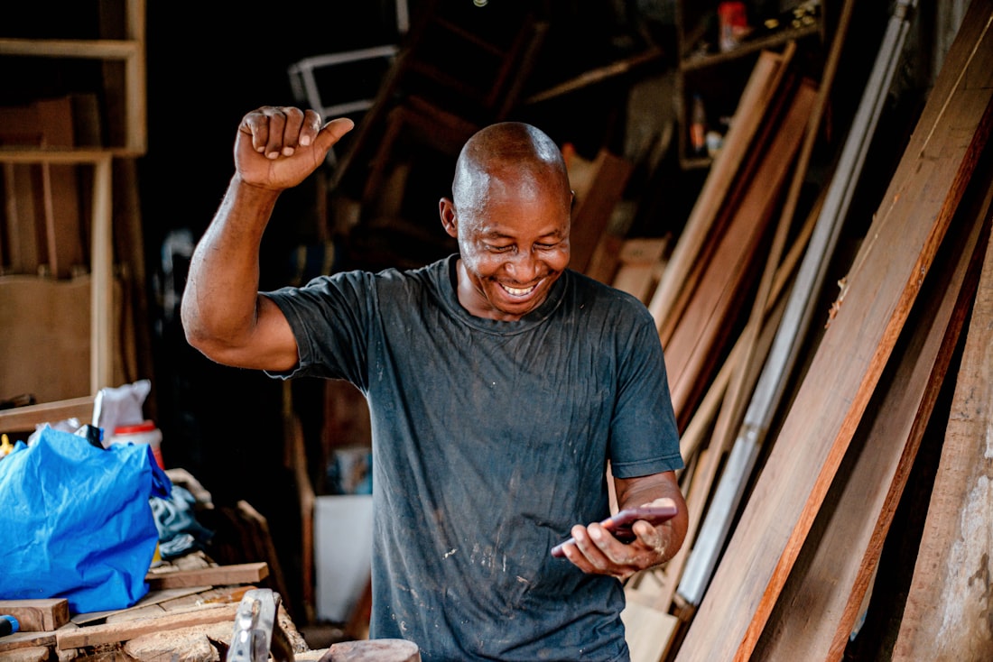 A man smiling while looking at his phone